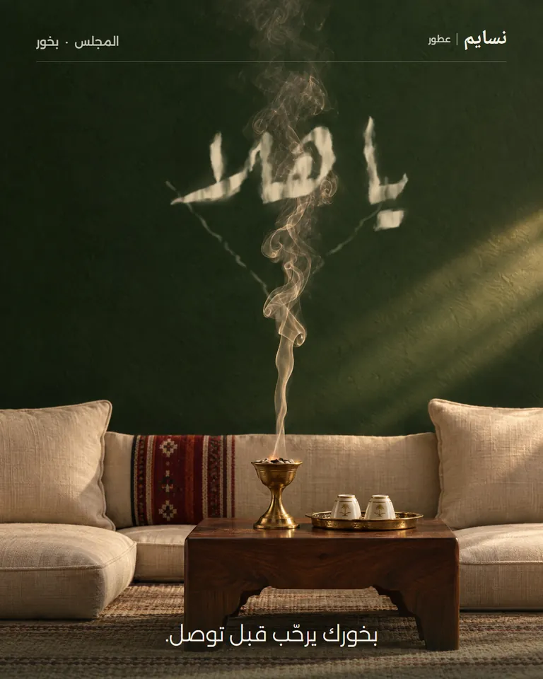 تصميم توضيحي لعلامة غير حقيقية: نسايم، عطور، بخور. مجلس فاضي قبل وصول الضيوف، ودخان المبخرة يكتب «يا هلا» على الجدار. العنوان: «بخورك يرحّب قبل توصل.».